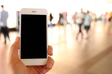 Metro istasyonunun arka planında akıllı telefon var.