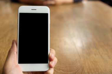 Masanın üzerinde el ele tutuşan akıllı telefon.