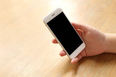 Masanın üzerinde el ele tutuşan akıllı telefon.