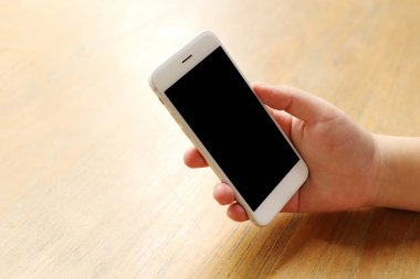 Masanın üzerinde el ele tutuşan akıllı telefon.