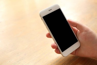 Masanın üzerinde el ele tutuşan akıllı telefon.