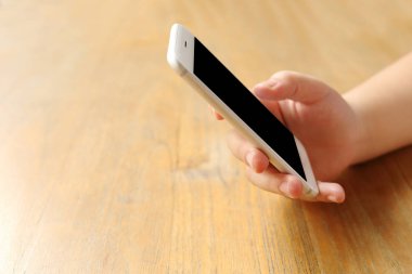 Masanın üzerinde el ele tutuşan akıllı telefon.