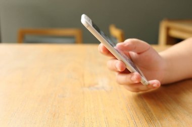 Masanın üzerinde el ele tutuşan akıllı telefon.