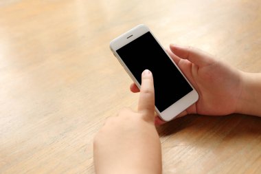 Masanın üzerinde el ele tutuşan akıllı telefon.