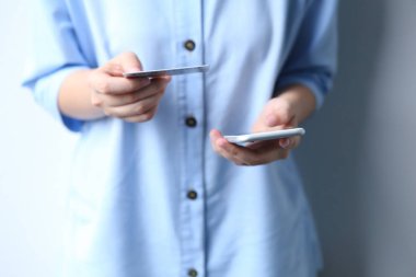 Kredi kartı ödeyen bir kadın akıllı telefondan online alışveriş yapıyor.