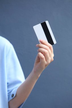 Üzerinde kredi kartı olan mavi gömlekli bir kadın.