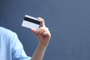 Üzerinde kredi kartı olan mavi gömlekli bir kadın.