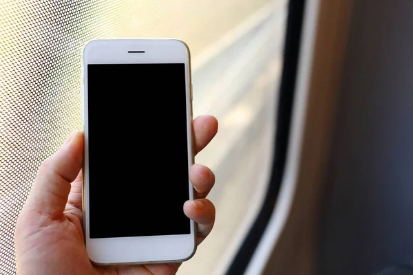 Рука держит смартфон в поезде — стоковое фото