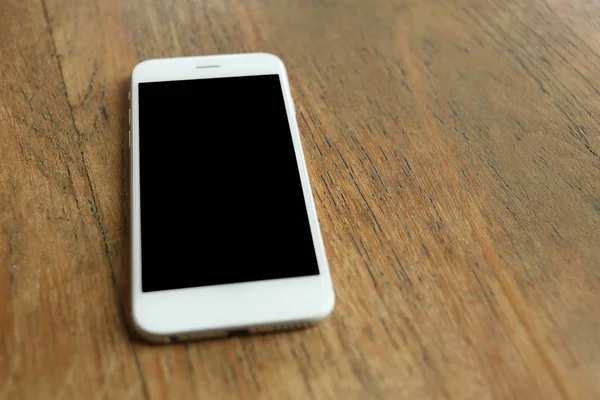 Ahşap masadaki akıllı telefon