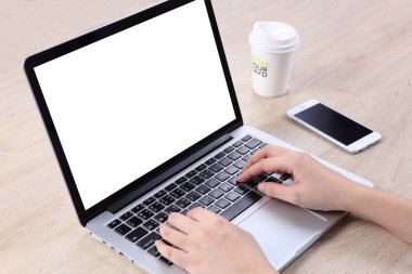 İş kadını, ahşap masadaki akıllı telefonuyla laptop 'ı taklit ediyor.