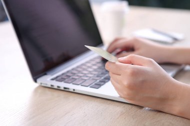Ecommerce concept, Woman using credit card with ecommerce website via laptop on wooden desk