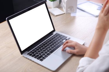 Business woman using mock up laptop on wooden desk