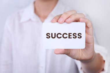 Woman holding with showing front view of white card