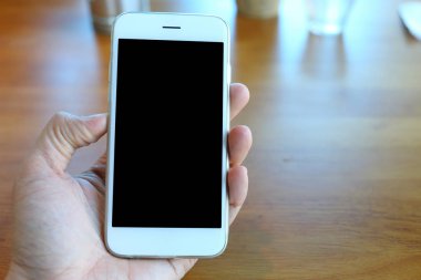 Hand holding smartphone with coffee shop background