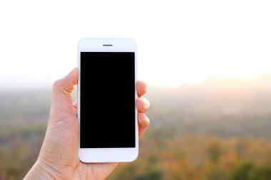 Güneş ışığı ve dağ arka plan ile Smartphone tutan el