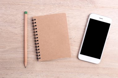 Boş ekran smartphone ile defter ve kalem ahşap backg üzerinde