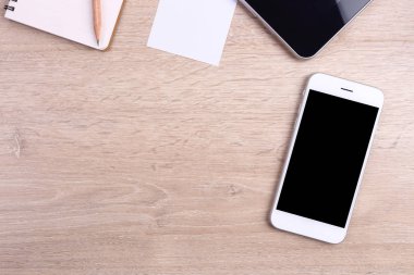 Üstten Görünüm akıllı telefon, tablet ve ofis malzemeleri ahşap backgr