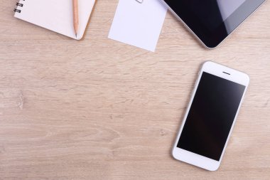 Üstten Görünüm akıllı telefon, tablet ve ofis malzemeleri ahşap backgr