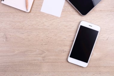Üstten Görünüm akıllı telefon, tablet ve ofis malzemeleri ahşap backgr