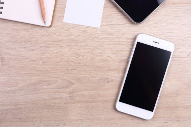Üstten Görünüm akıllı telefon, tablet ve ofis malzemeleri ahşap backgr