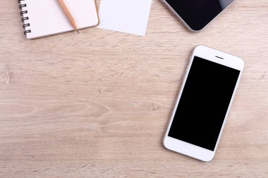 Üstten Görünüm akıllı telefon, tablet ve ofis malzemeleri ahşap backgr