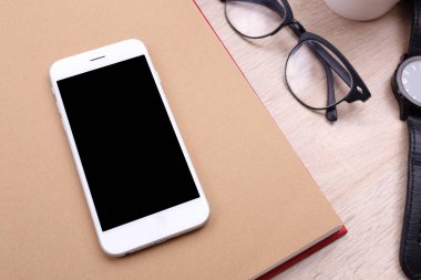 kitap ve ahşap arka plan üzerinde gözlük Smartphone