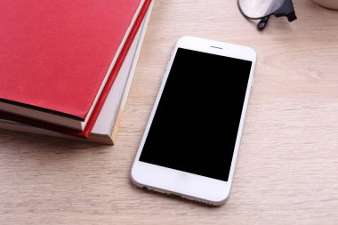 Smartphone ve ahşap arka plan üzerinde kitap
