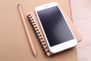Kalem kitap ve ahşap arka plan ile Smartphone