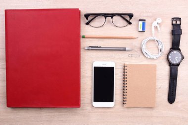 Smartphone, kitap ve ofis malzemeleri ahşap arka plan üzerinde