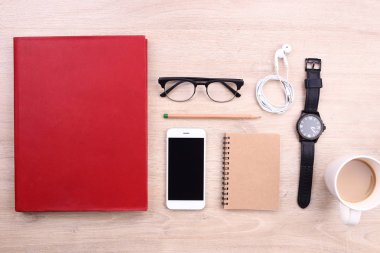 Smartphone, kitap ve ofis malzemeleri ahşap arka plan üzerinde
