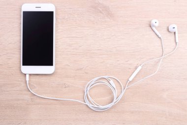 Boş ekran smartphone ile ahşap arka plan üzerinde kulaklık