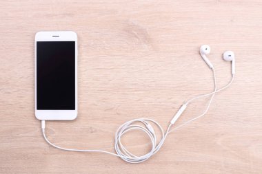 Boş ekran smartphone ile ahşap arka plan üzerinde kulaklık
