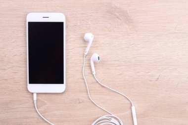 Boş ekran smartphone ile ahşap arka plan üzerinde kulaklık