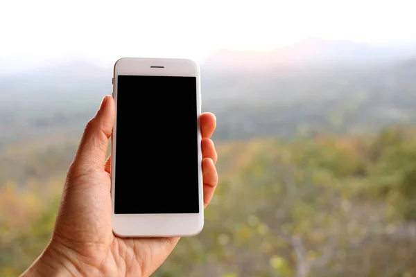 Ручной смартфон с горным фоном — стоковое фото
