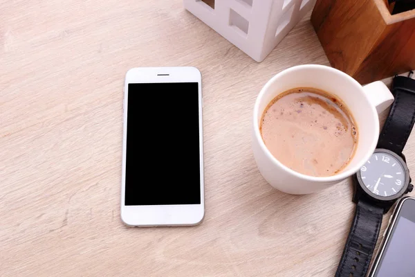 Smartphone en koffie cup op houten achtergrond — Stockfoto