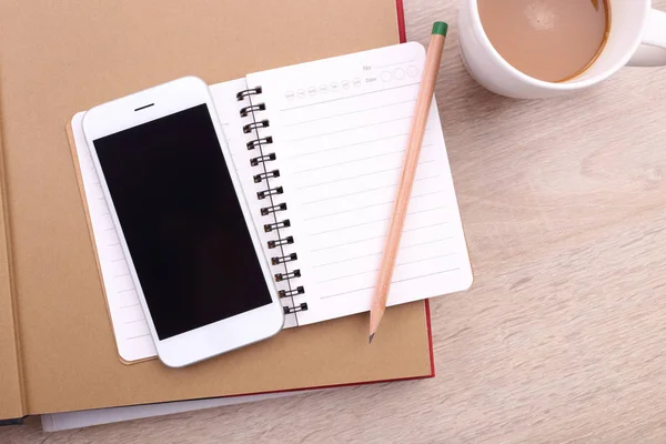 Smartphone a schermo bianco con matita e taccuino sul retro in legno — Foto Stock