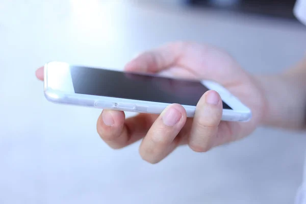 Tenuta a mano smartphone a colori bianchi — Foto Stock
