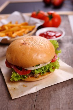 Hamburger ahşap arka plan üzerinde patates kızartması ile