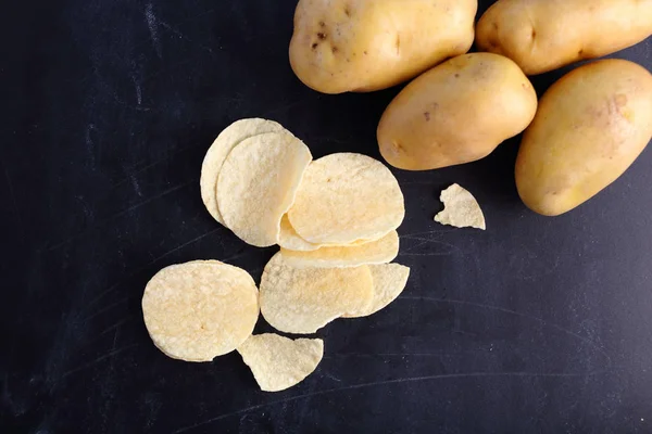 Картофельные чипсы на черном фоне — стоковое фото