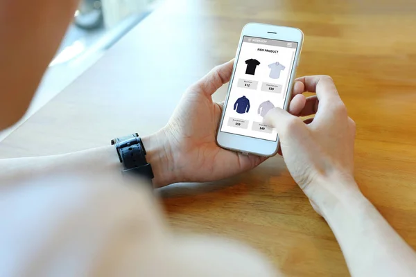 Man bedrijf smartphone met Kies shirt op e-commerce website — Stockfoto