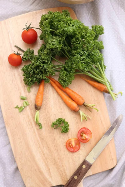Parsley, carrot and tomato on chopping block — Stock Photo, Image
