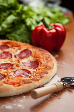 Salamlı pizza masada.