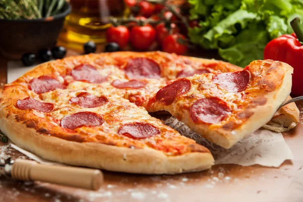 Salami pizza lifted 1 slice — Stock Photo, Image