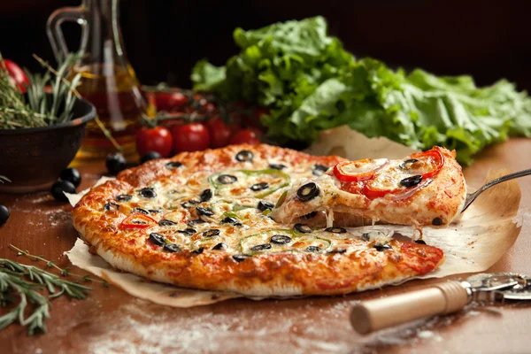 Vegetable pizza lifted 1 slice — Stock Photo, Image