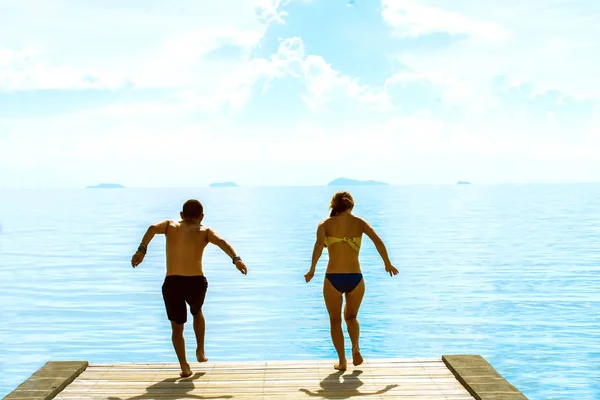 Uma rapariga e um tipo estão a saltar para o mar. Koh Samui, Tailândia — Fotografia de Stock