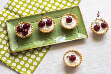 Krem, çilek ve ahşap üzerine yaban mersini meyve tatlı tart
