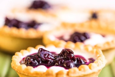 Krem, çilek ve ahşap üzerine yaban mersini meyve tatlı tart