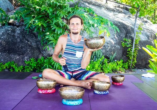 Singing Tibetan bowls. The man is playing on the bowls for the g