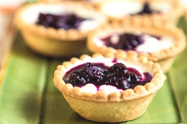 Krem, çilek ve ahşap üzerine yaban mersini meyve tatlı tart