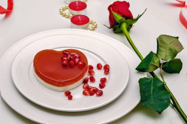 Kalp kırmızı beyaz bir levha pastaya şeklinde. Sevgililer günü romantik akşam yemeği için lezzetli tatlı